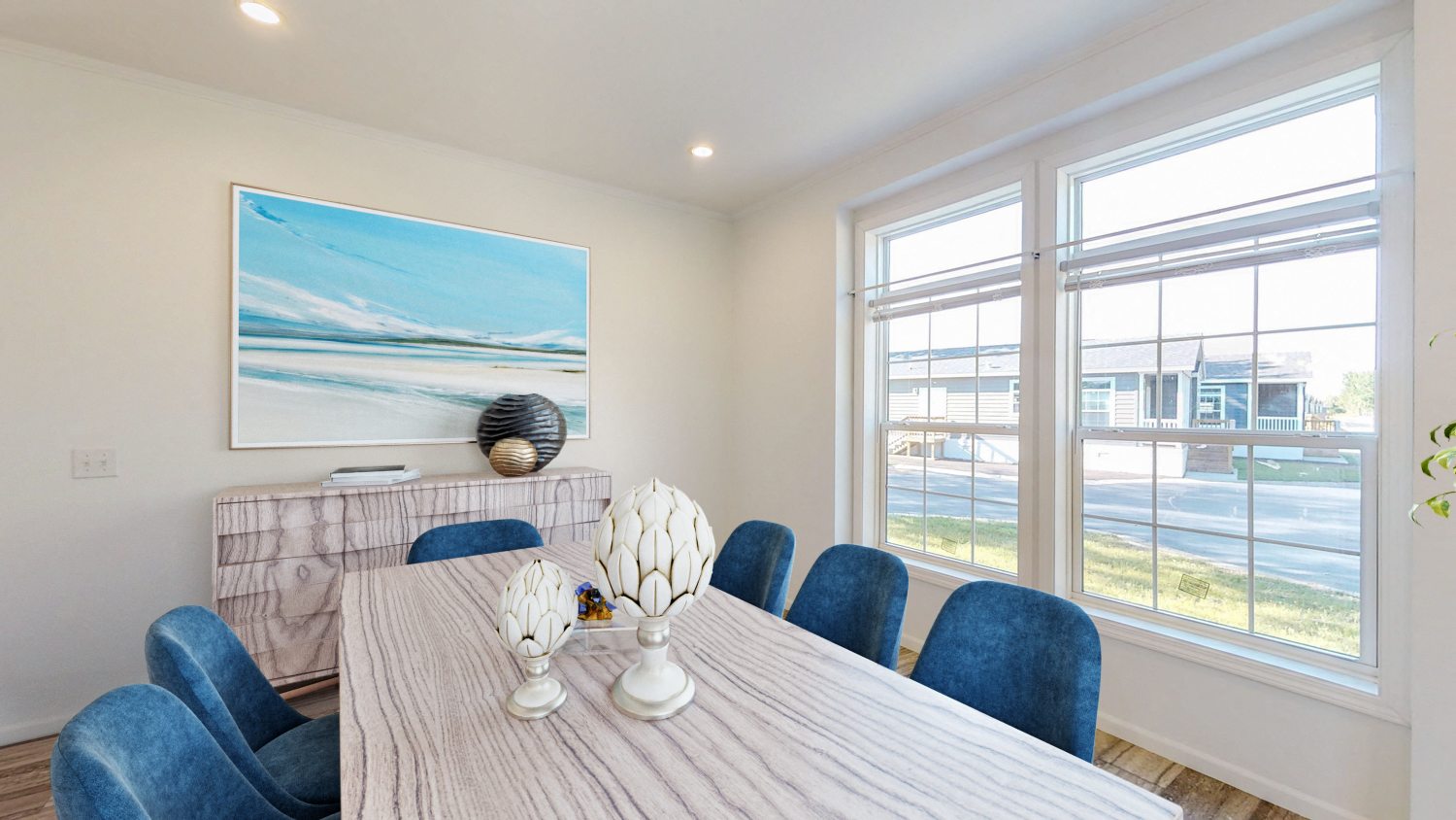 a dining room with large windows and a table with blue chairs
