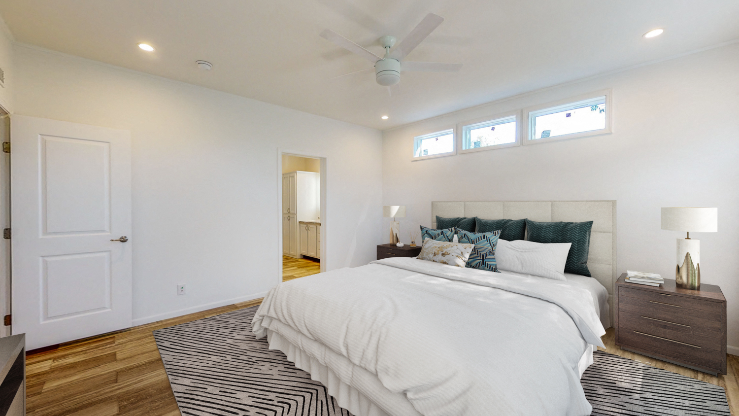 a white bedroom with a white bed and a zebra rug