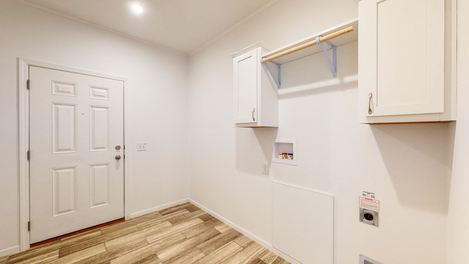 a white room with a door and a white closet and a wood floor