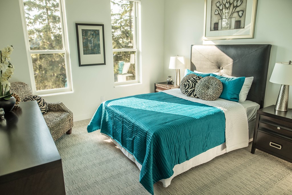 a bedroom with a bed and two windows