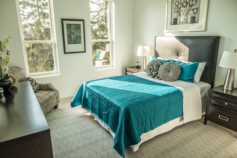 a bedroom with a bed and two windows