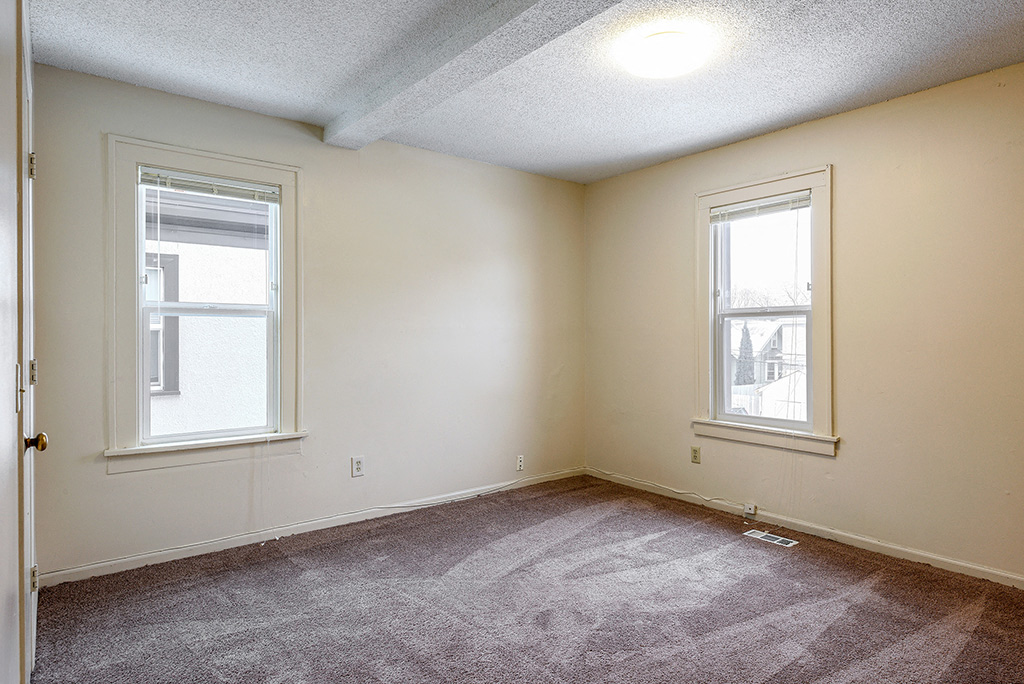 the living room of an empty house with two windows