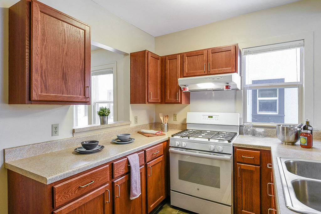 a kitchen with wooden cabinets and a stove and a sink