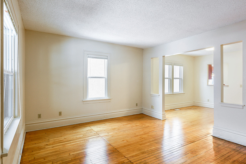 the living room and dining room of an empty house with wood floors