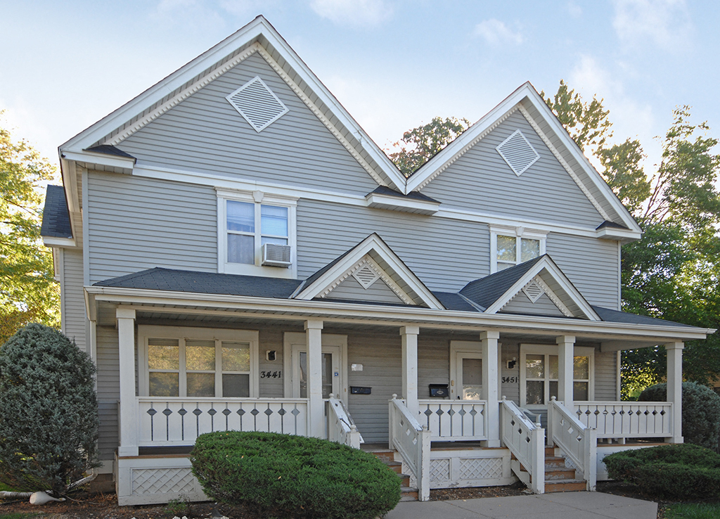 a blue house with a porch and a porch swing