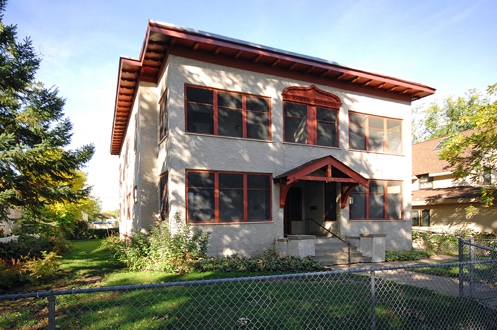 a white house with a fence in front of it