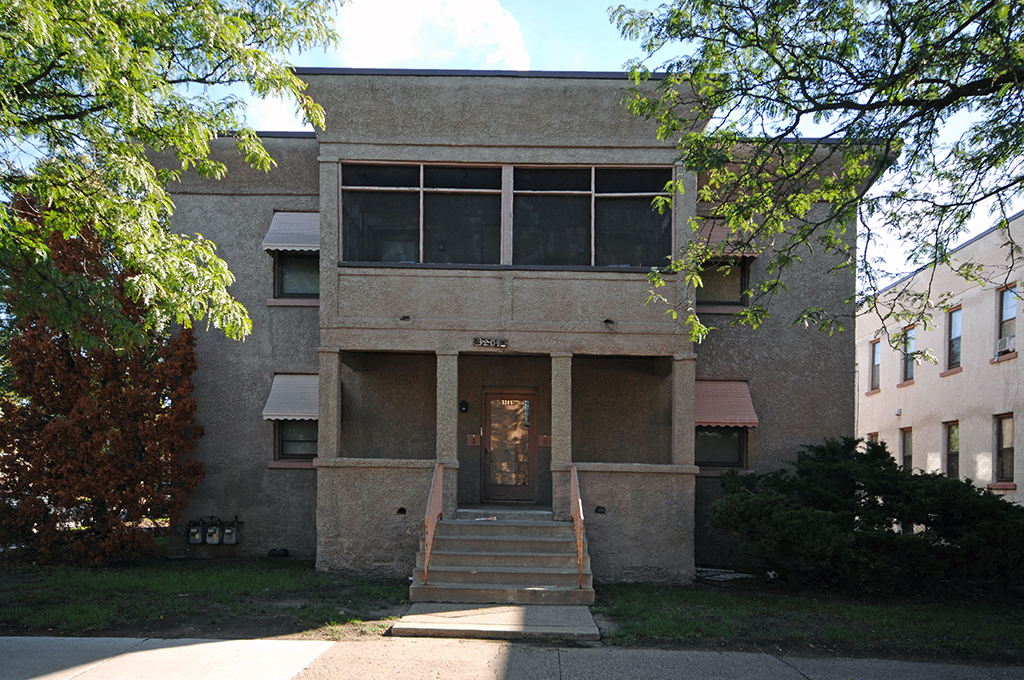 the front of a building with stairs and a door