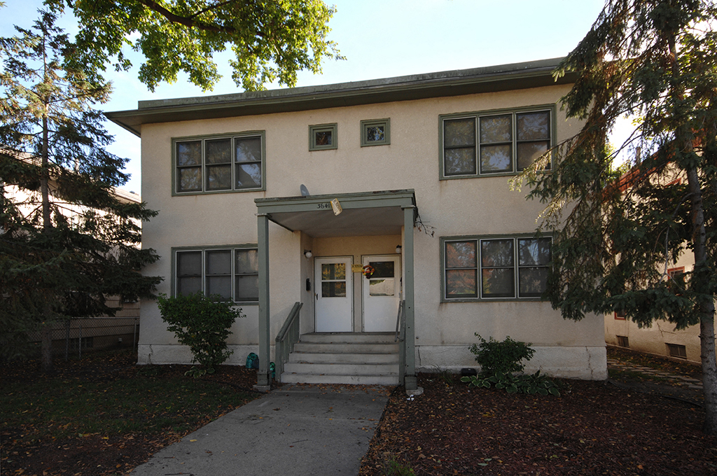 the front of a white house with a porch and stairs