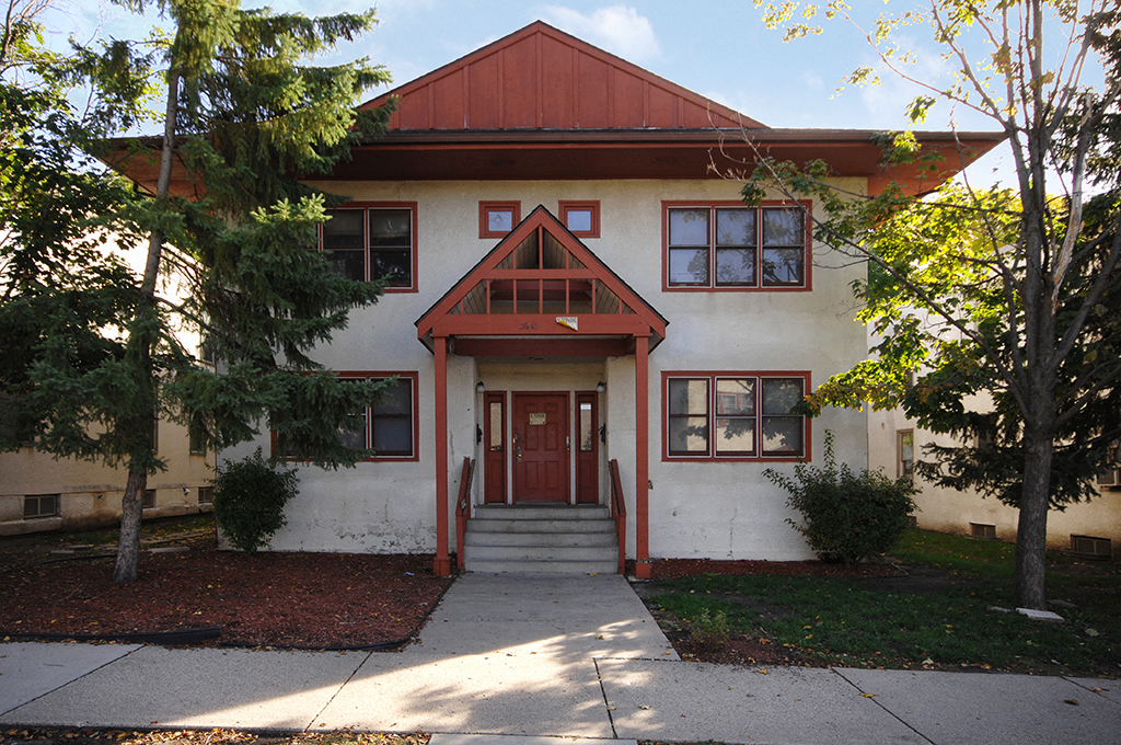 the front of a white house with a red roof