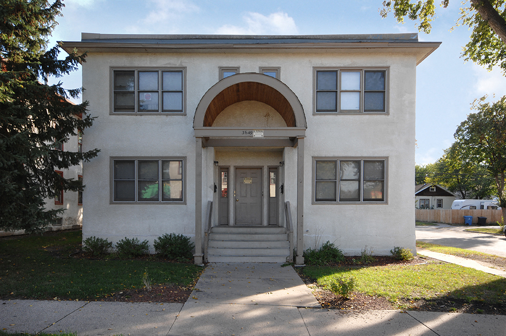 the front of a white house with a sidewalk in front of it