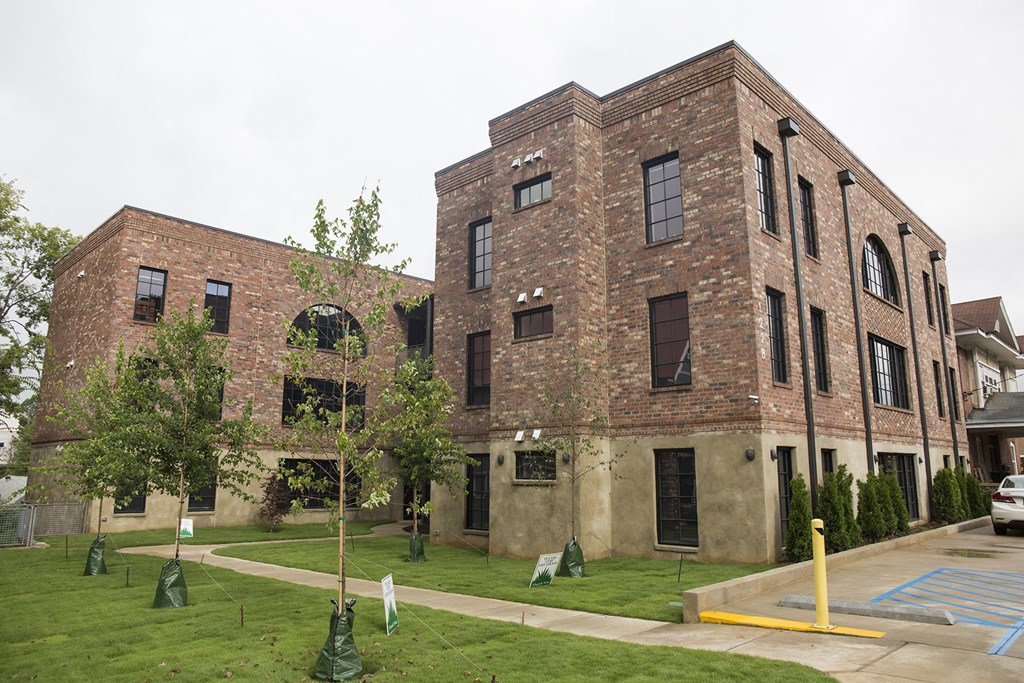 the exterior of a brick building with grass and trees