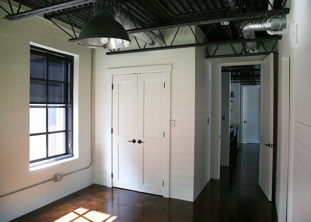 a living room with white walls and a window and a white door