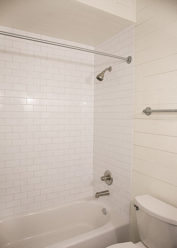 a white bathroom with a tub and a toilet