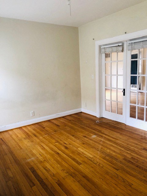 an empty room with a wooden floor and doors