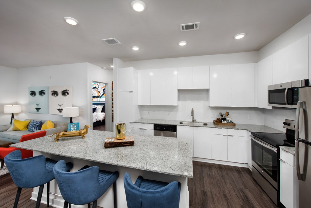 an open kitchen and living room with a granite counter top