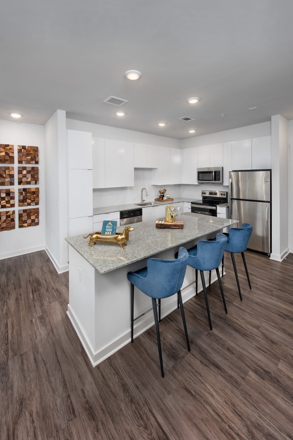 a kitchen with stainless steel appliances and an island with blue chairs