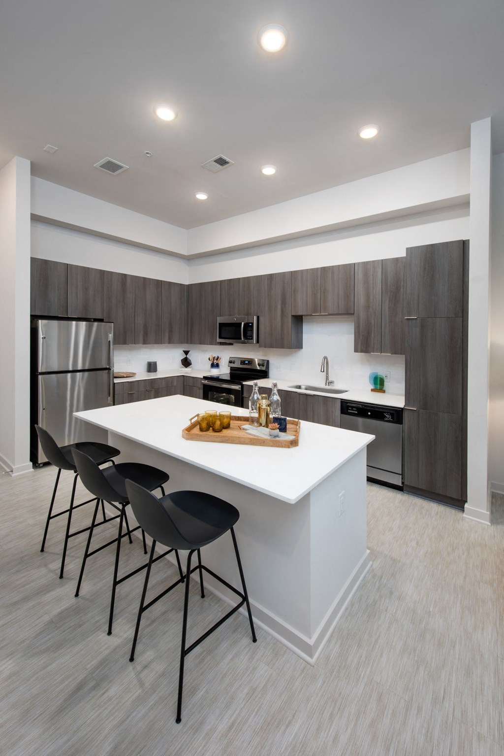 a kitchen with a large island with black bar stools
