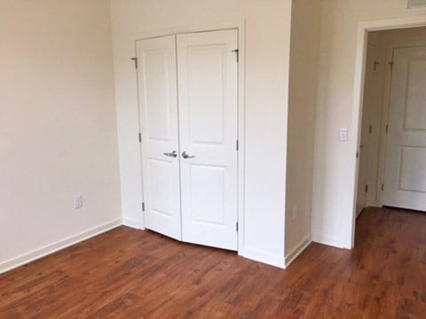 an empty room with two closets and a wooden floor