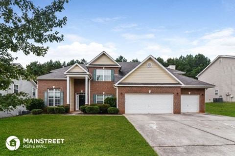 a brick house with a garage and a lawn