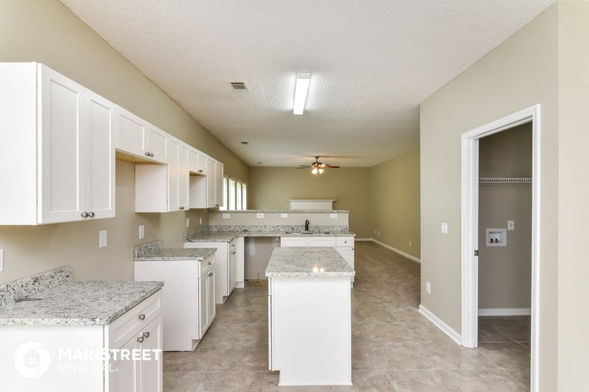 a kitchen with white cabinets and granite counter tops