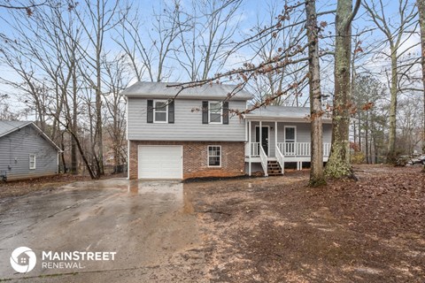 a white house with a driveway and trees