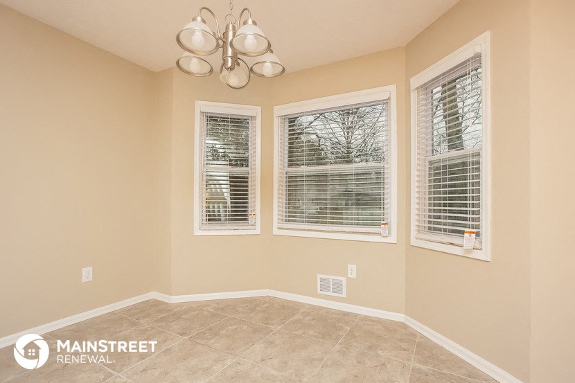 the living room of a home with three windows
