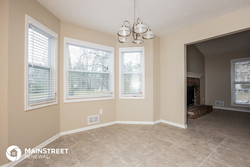 the living room and dining room of a home with a fireplace