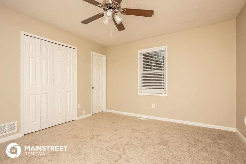 the master bedroom has a ceiling fan and a closet