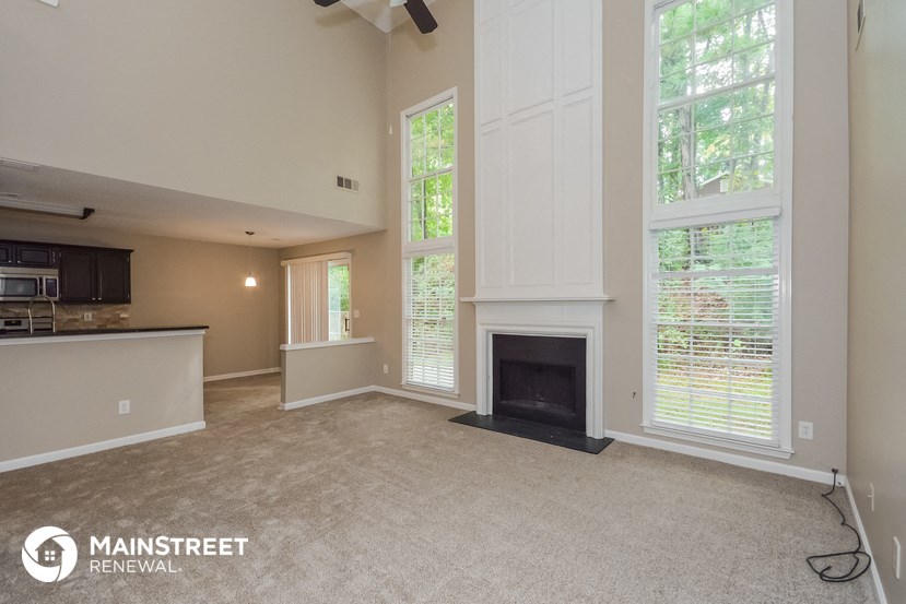 the living room and kitchen of a home with a fireplace