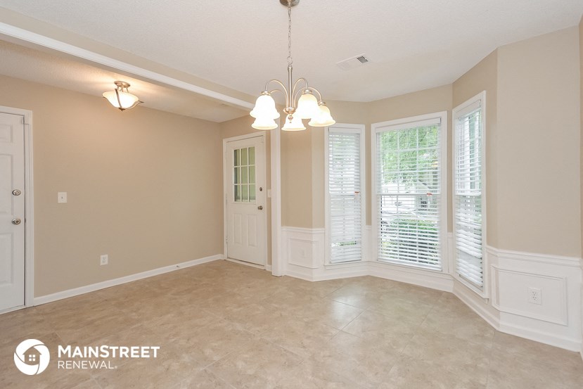 an empty dining room with windows and a door