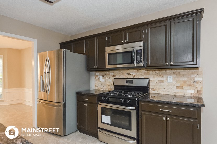 the kitchen has stainless steel appliances and black cabinets
