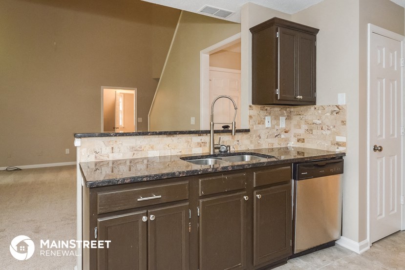 a kitchen with granite counter tops and wooden cabinets