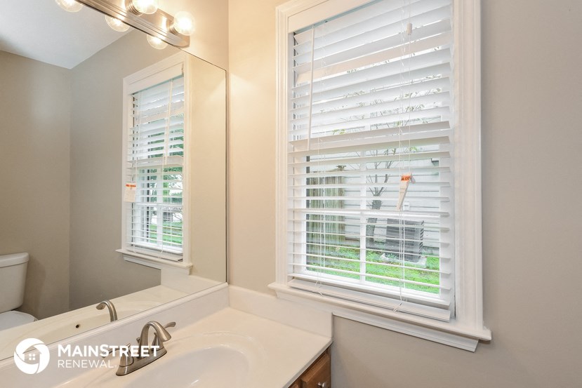 a bathroom with a sink and a mirror and a window