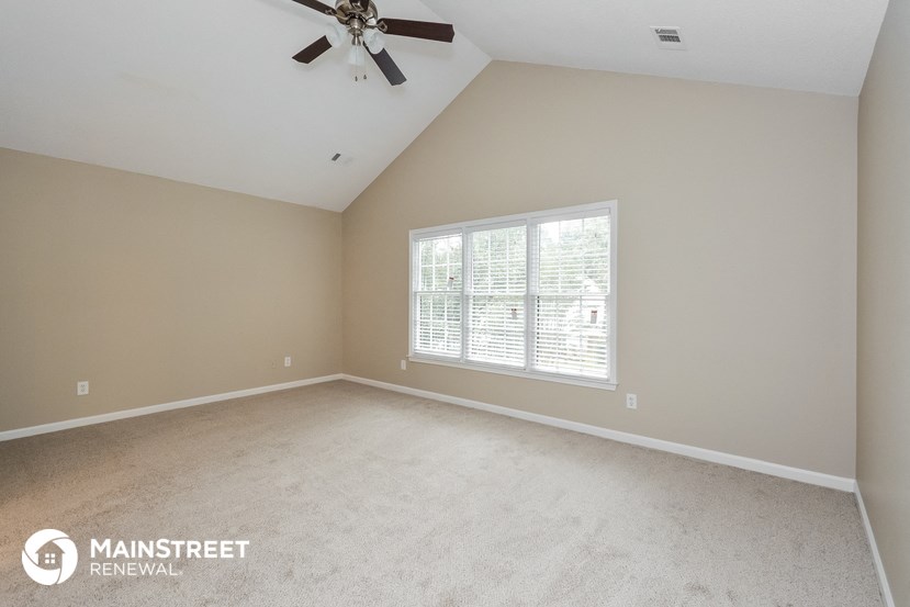 the master bedroom with carpet and a ceiling fan