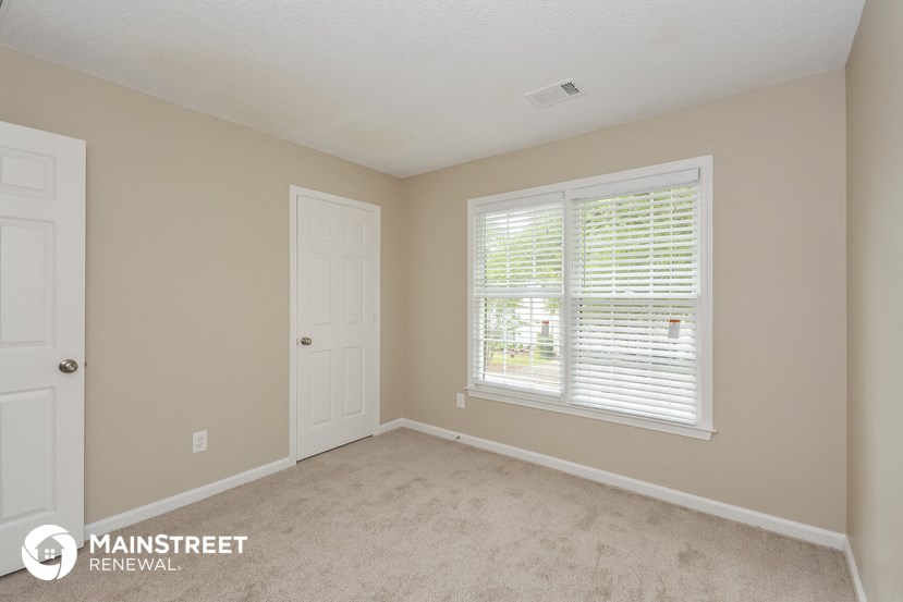 a bedroom with a large window and a white door
