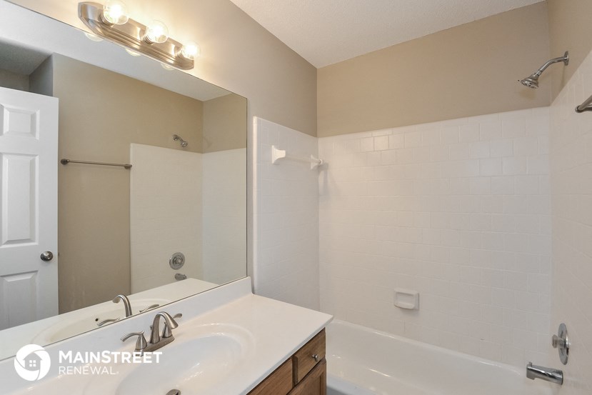 a bathroom with a sink and a tub and a mirror