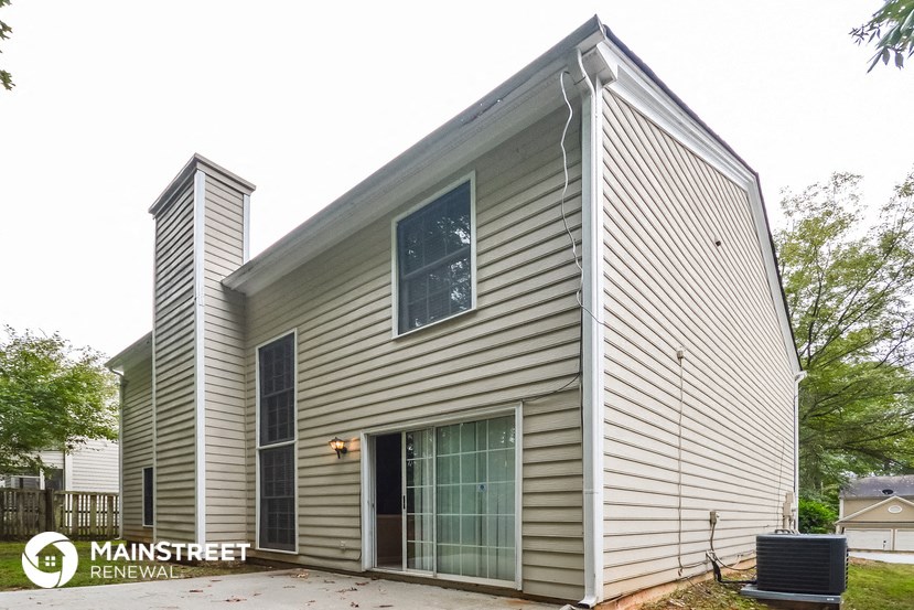 the exterior of a house with gray siding and a window