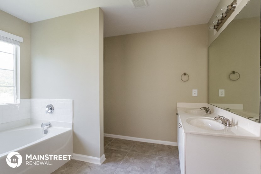 a bathroom with a tub and a sink and a mirror
