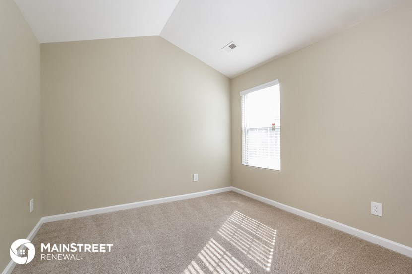 a spacious room with carpet and a large window