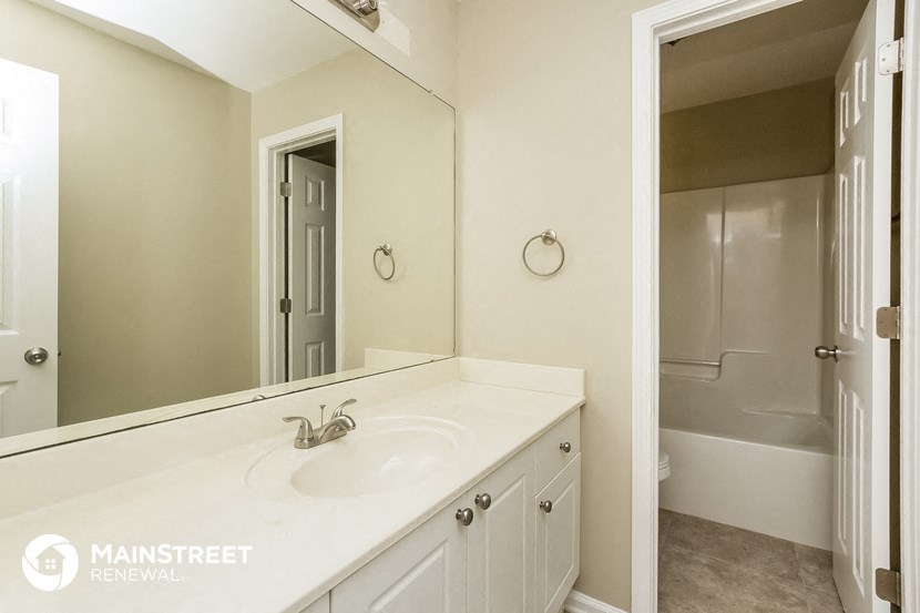 a white bathroom with a sink and a mirror
