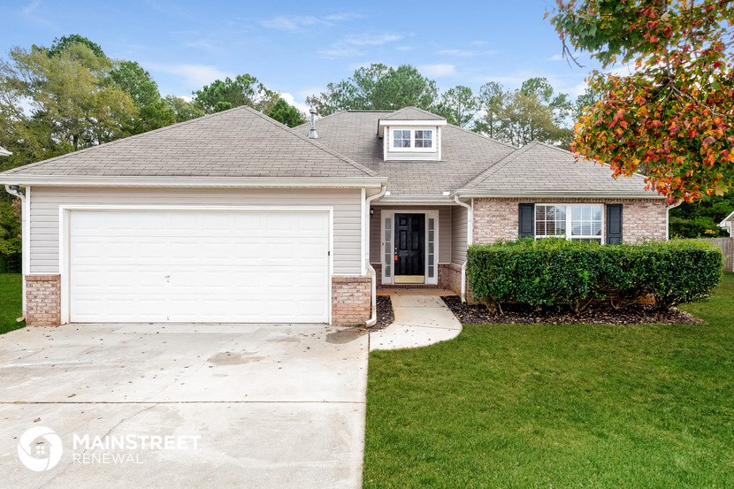 a home with a white garage door and a lawn