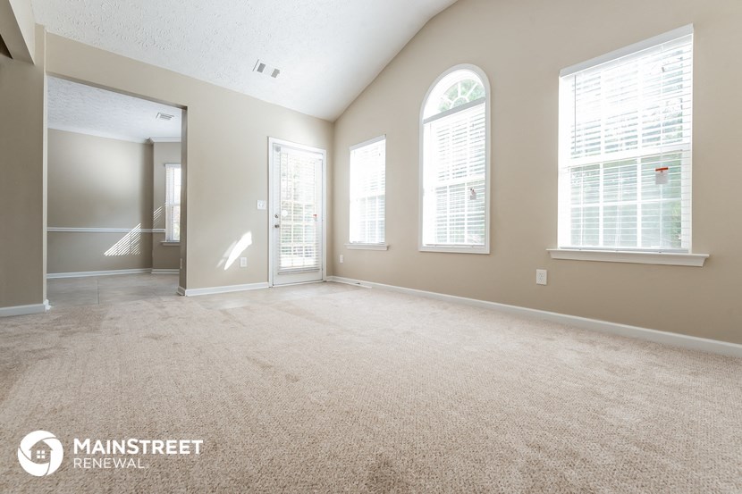 the living room of an empty house with a large window