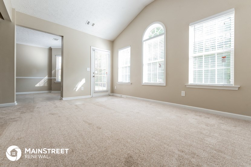 the living room and dining room of an empty house