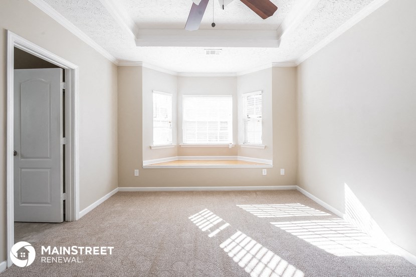 an empty room with a window and a ceiling fan