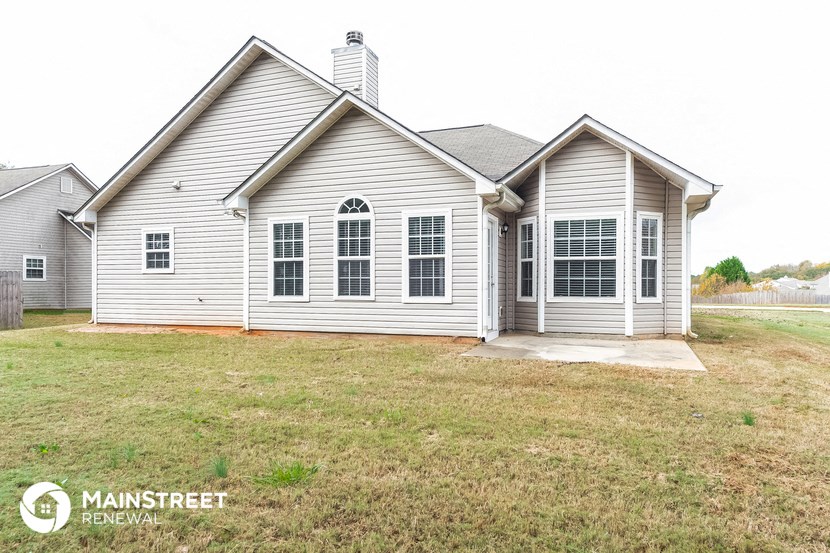 the front of a house with a lawn and a driveway