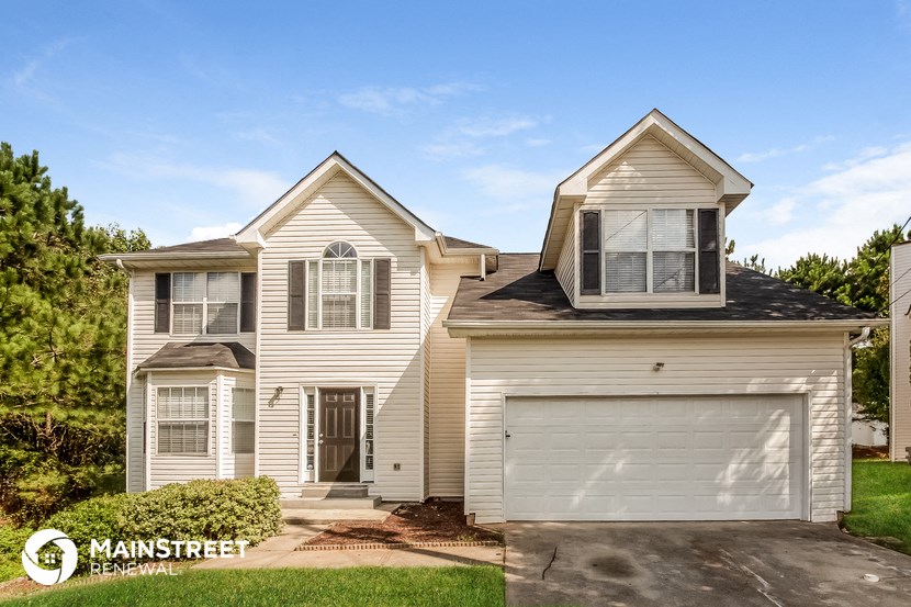 a white house with a garage with a blue sky