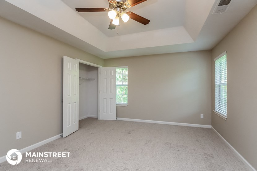 the master bedroom is spacious and has a ceiling fan