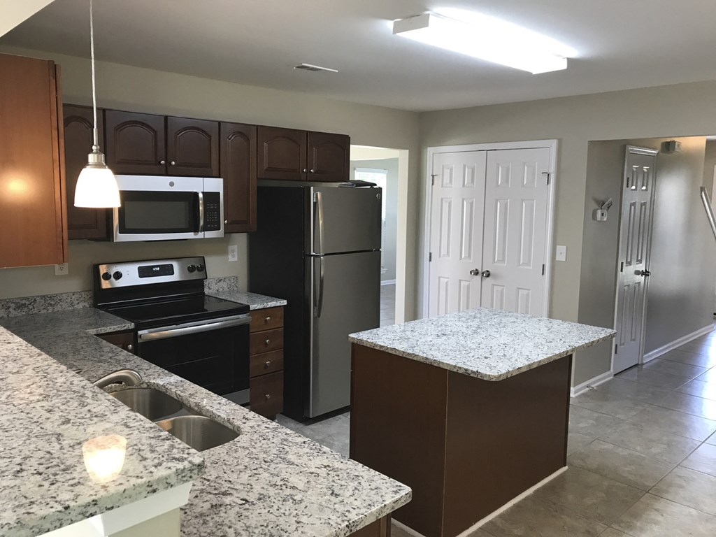 a kitchen with granite counter tops and stainless steel appliances