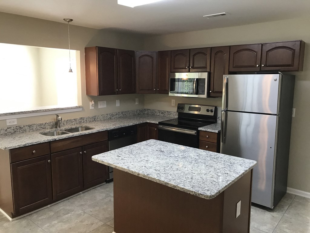 a kitchen with granite counter tops and stainless steel appliances