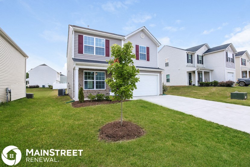 a small tree in the front yard of a house